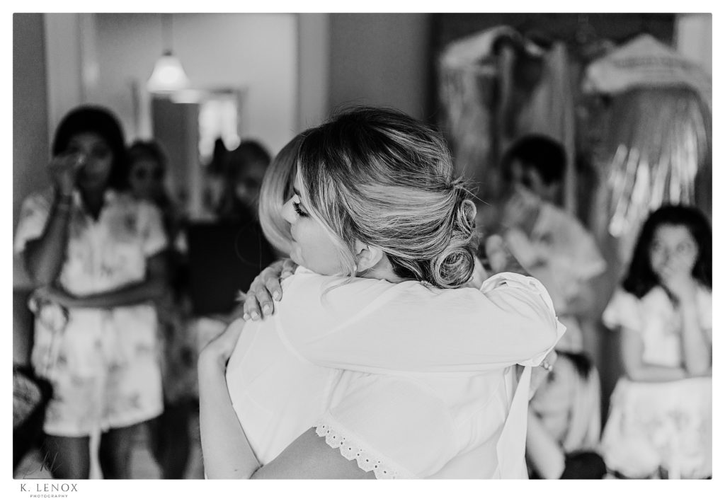 Candid, photojournalistic photo of a mom and bride hugging on the wedding day. 