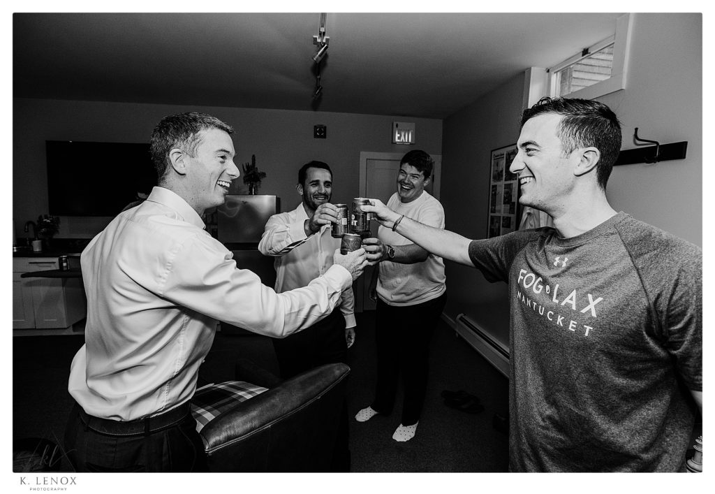 Candid and Photojournalistic Black and White photo of men toasting with Beer before they get dressed for a wedding. 