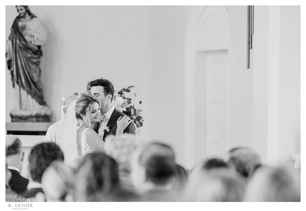Black and White photo of a Bride and Groom having a sweet little kiss during their wedding ceremony at St. Andrews in Waterbury VT