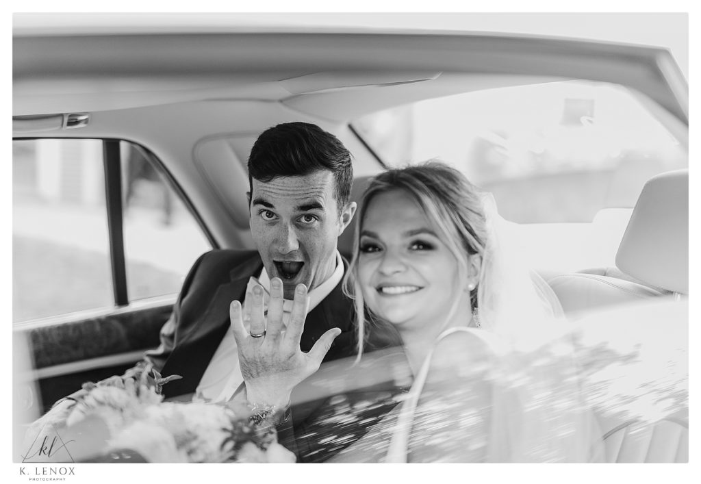 Groom Shows off his Wedding band while sitting in the back of a car. 