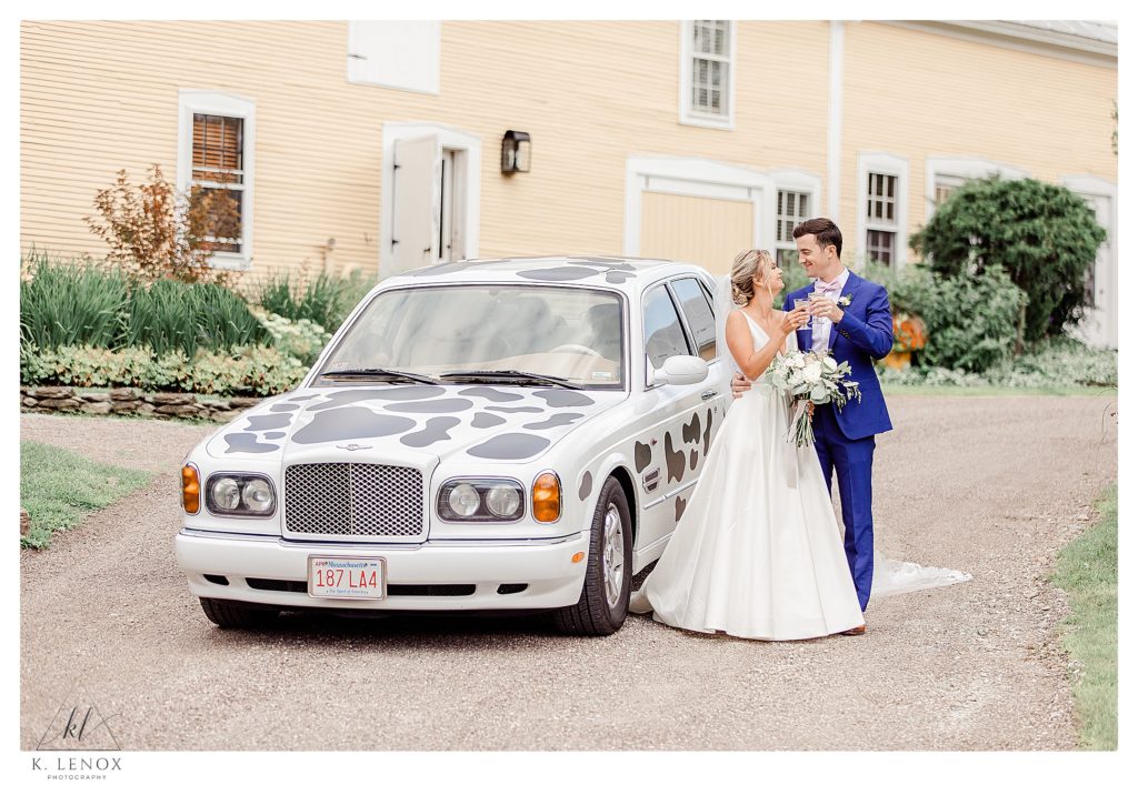 Bride and Groom have a toast with Vintage Champagne in front of the cow covered Bentley 
