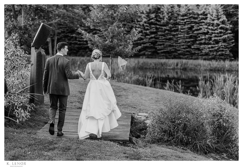 Wedding at Inn at the Round Barn- Black and White photo of a bride and groom walking on the property