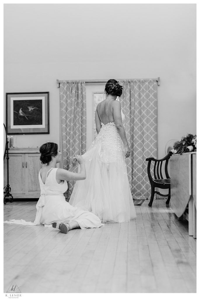 Bride gets her dress bustled while at . her Wedding at The West Mountain Inn