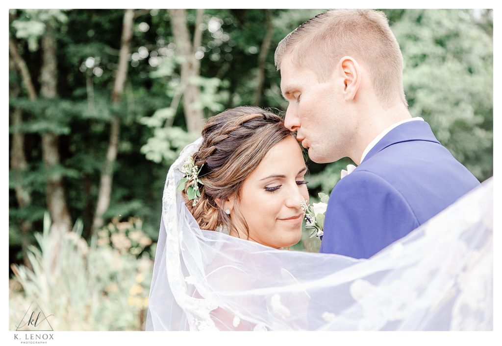 A light and Airy photograph with a bride and groom and a veil flowing. 