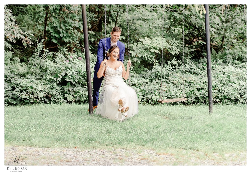 Bride and Groom swing on a swing set on their wedding day at the West Mountain Inn. 