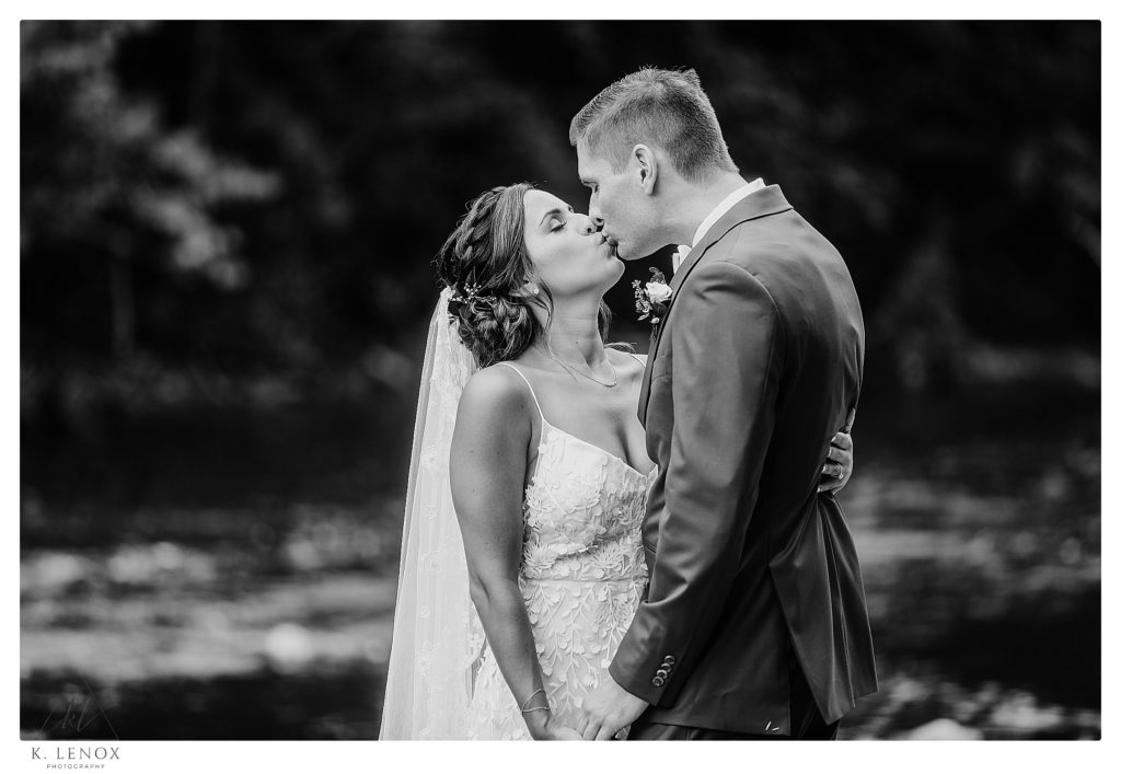 Black and White photograph of a Bride and Groom  kissing on their wedding day. 