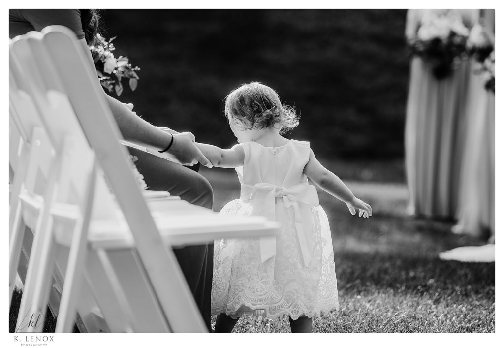 Black and White Candid photo of a little girl wearing a white dress