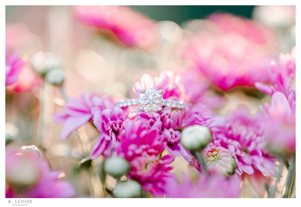 Light and Airy Engagement Session at Alyson's Orchard- a diamond solitaire engagement ring surrounded by pink flowers. 