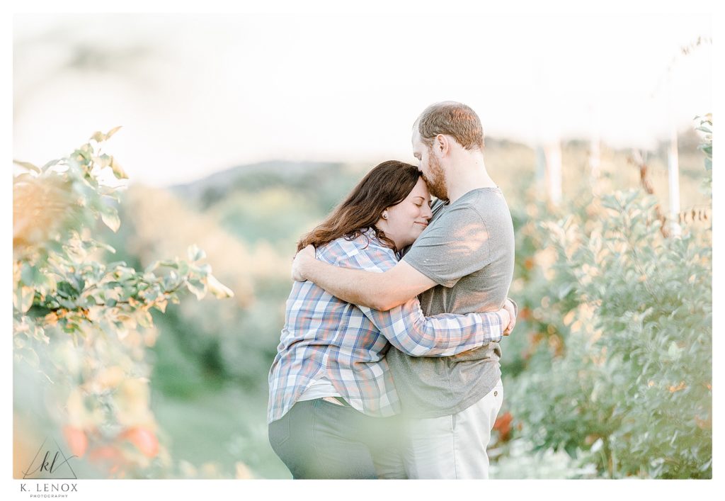 Light and Airy Engagement Session at Alyson's Orchard- showing a man and woman kissing. 