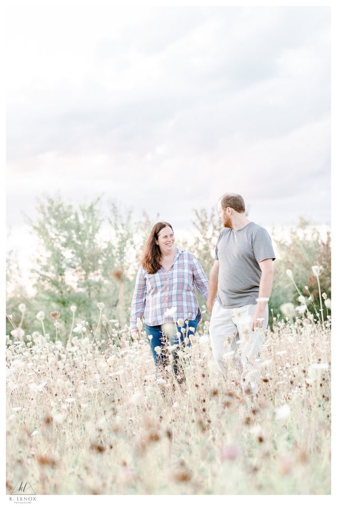Light and Airy Engagement Session at Alyson's Orchard- showing a man and woman in casual attire holding hands and smiling. 