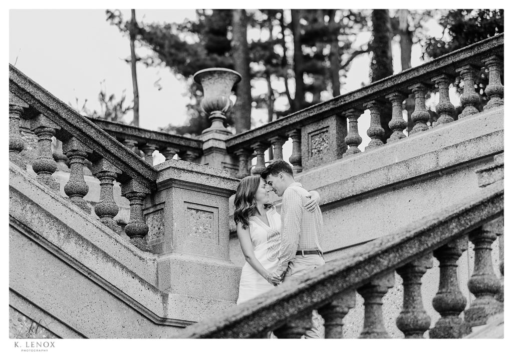 Black and White photo showing a man and woman on the stone staircase at the Crane Estates during their engagement session