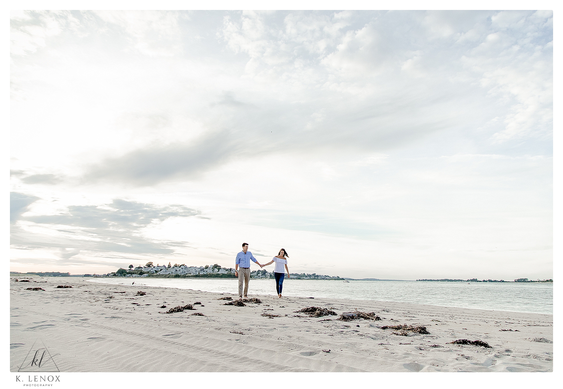 Couple walking hand in hand on the Beach during their Engagement Session at Crane Estates