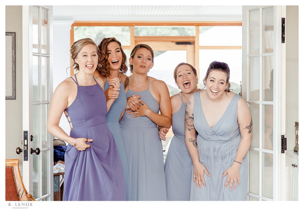 Bridesmaids are happy and smiling as they see the bride for the first time in her dress. 