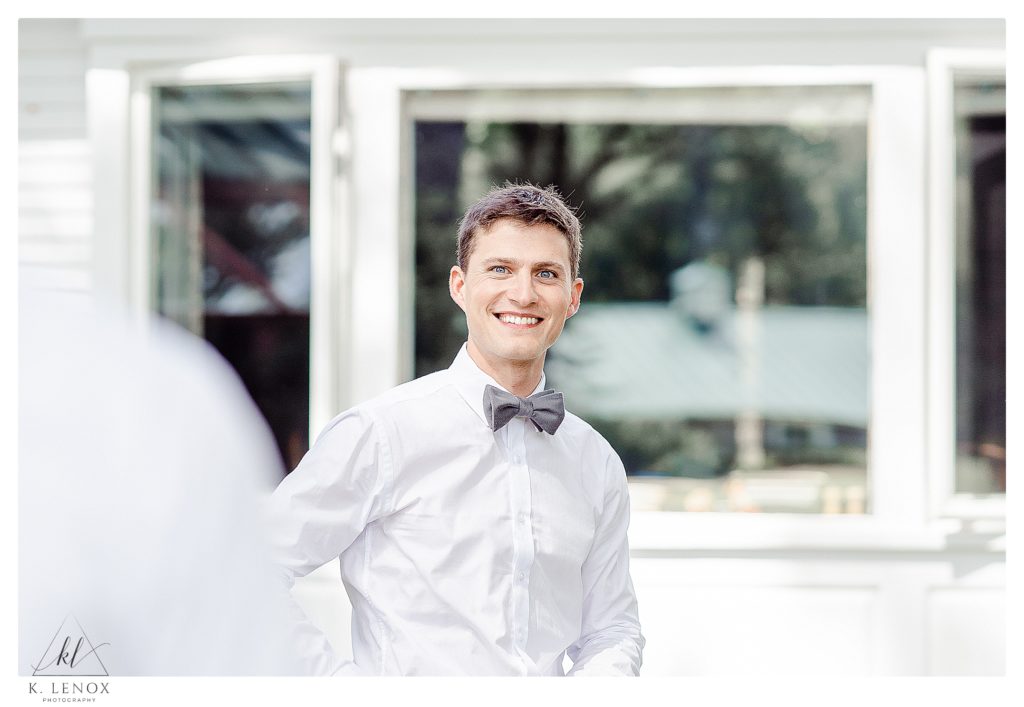 Light and Airy photo of a man wearing a white shirt and a grey bowtie. 