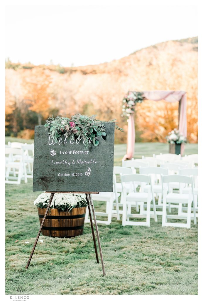 Wedding Ceremony for a Fall Wedding at the Grandview Estates, picture showing a wedding sign with an arbor in the background. 