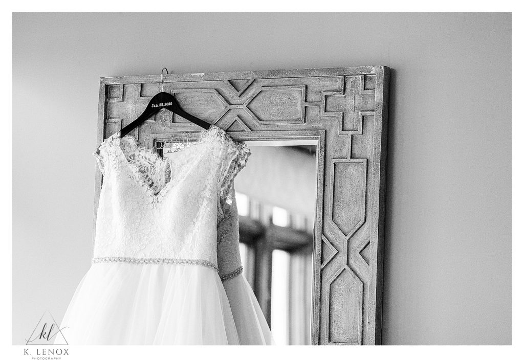 Winter Wedding at the Bedford Village Inn- Black and White image of a wedding dress hanging on a mirror. 