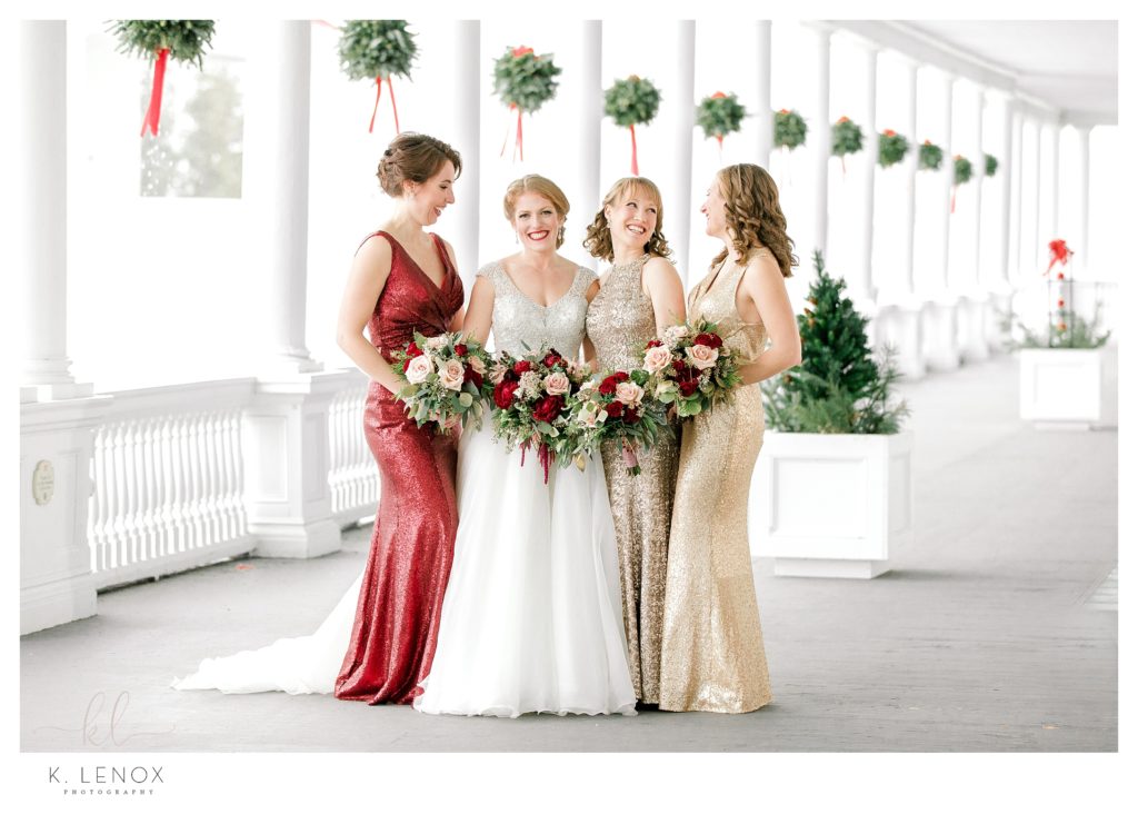 Bride and her bridesmaids on the veranda of the Omni Mount Washington Resort -during a Christmas Wedding in the Mountains. 