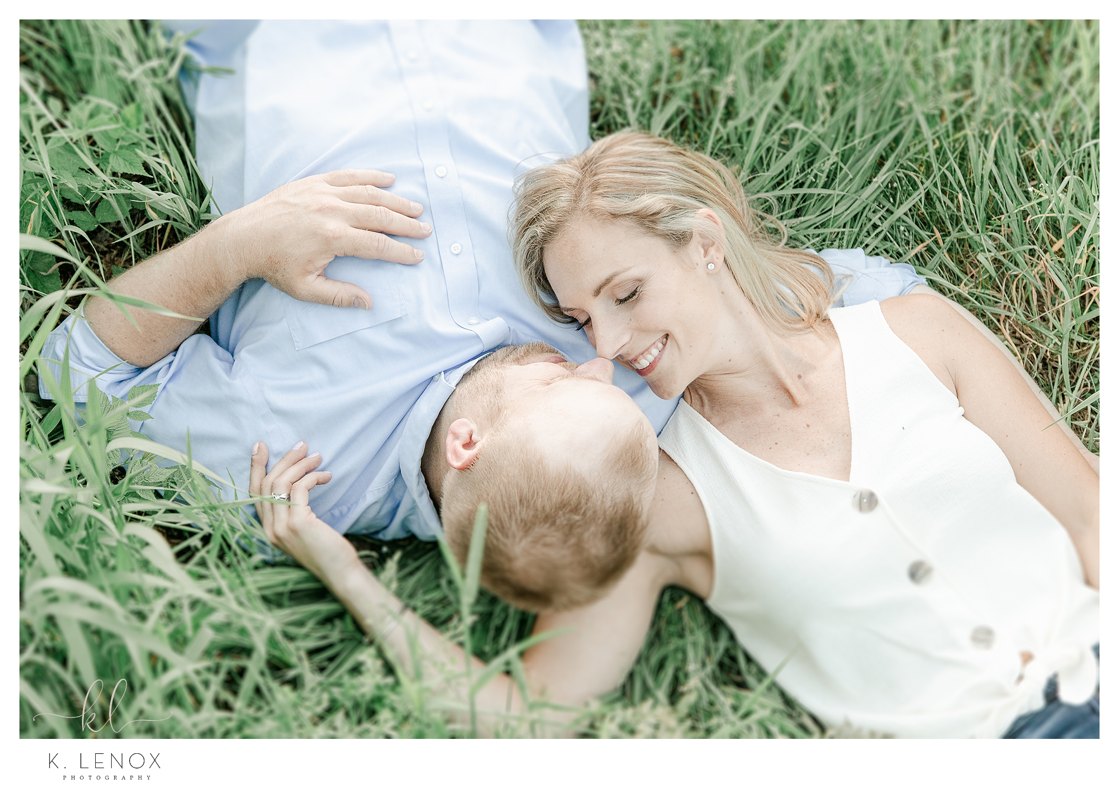 Man and Woman laying in the grass during a NH Engagement Session in Keene