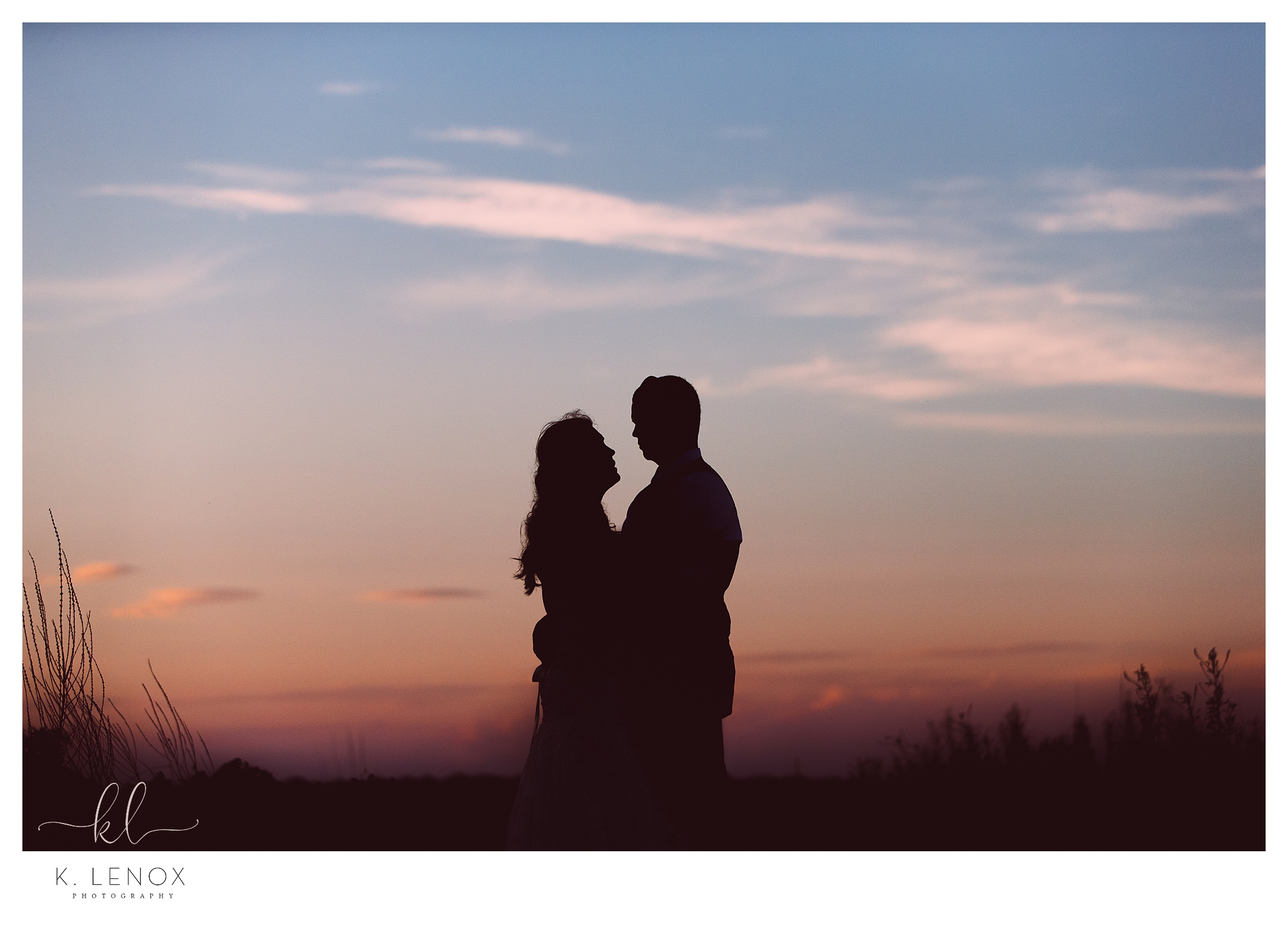 Silhouette of a man and woman at dusk while at the beach 