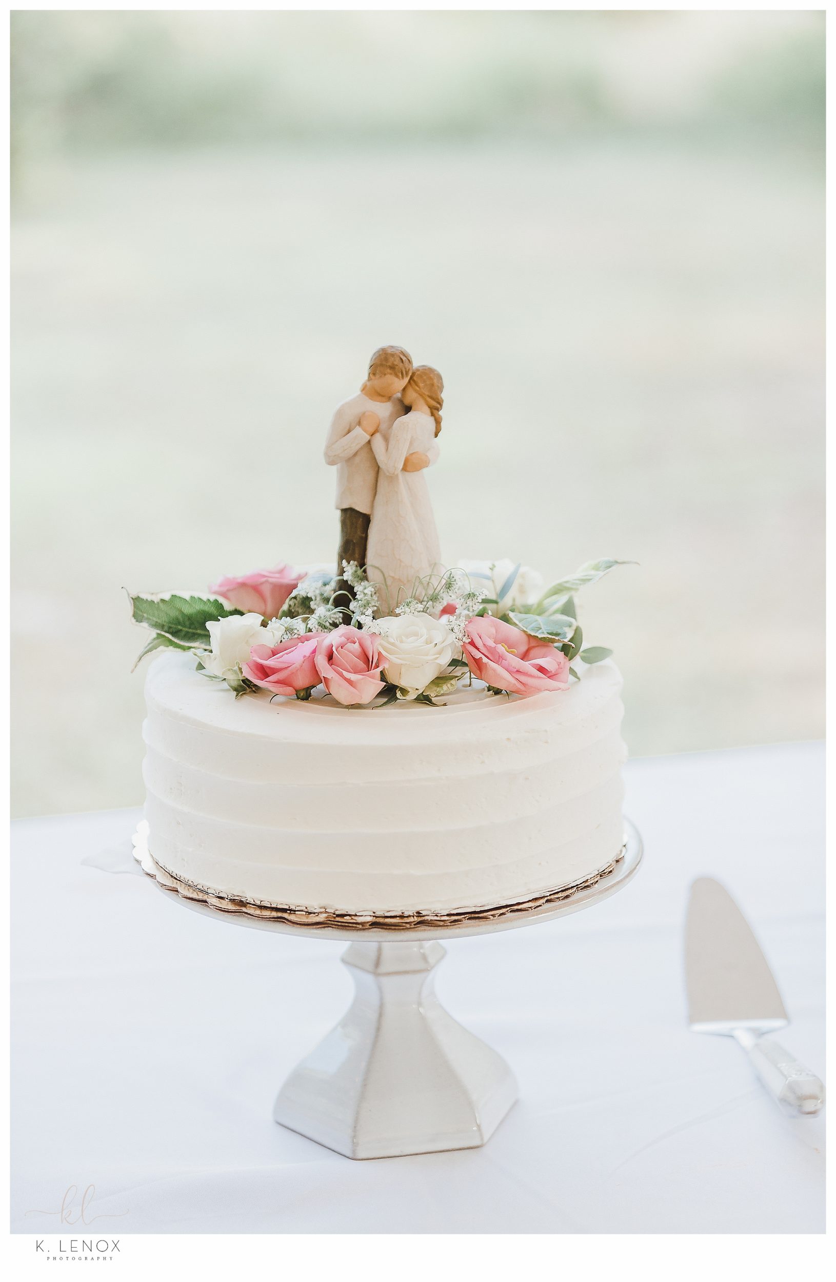 Intimate Wedding Celebration in Keene- Beautiful single tiered white wedding cake topped with flowers and whispering willow statue