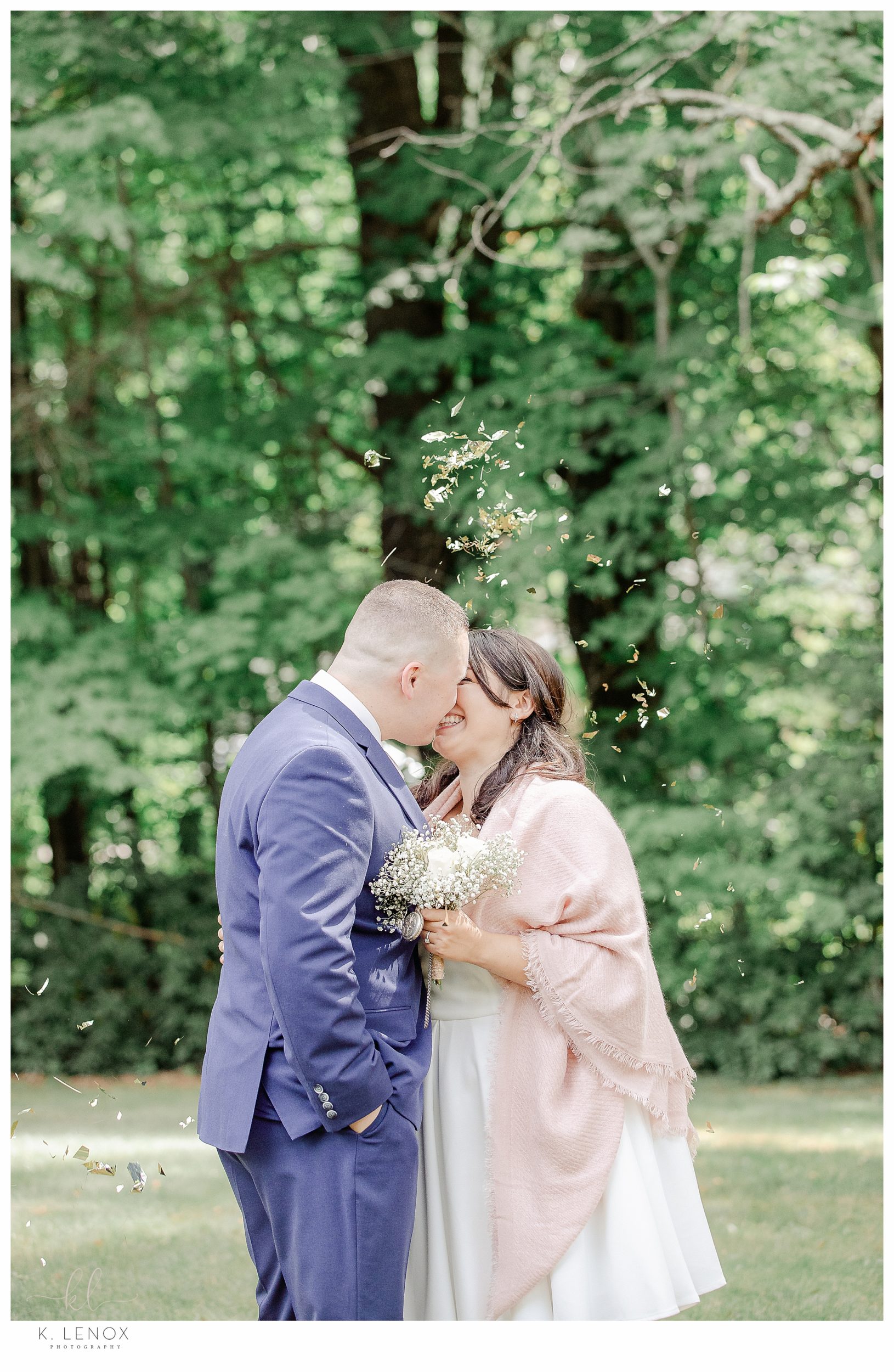 Light and Airy photo of a bride and groom kissing as confetti is thrown on them after their backyard elopement. 