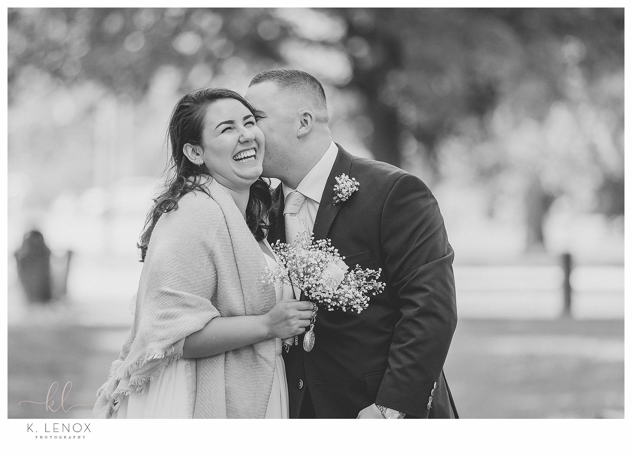 Black and White photo of a bride and groom laughing after their backyard elopement. 