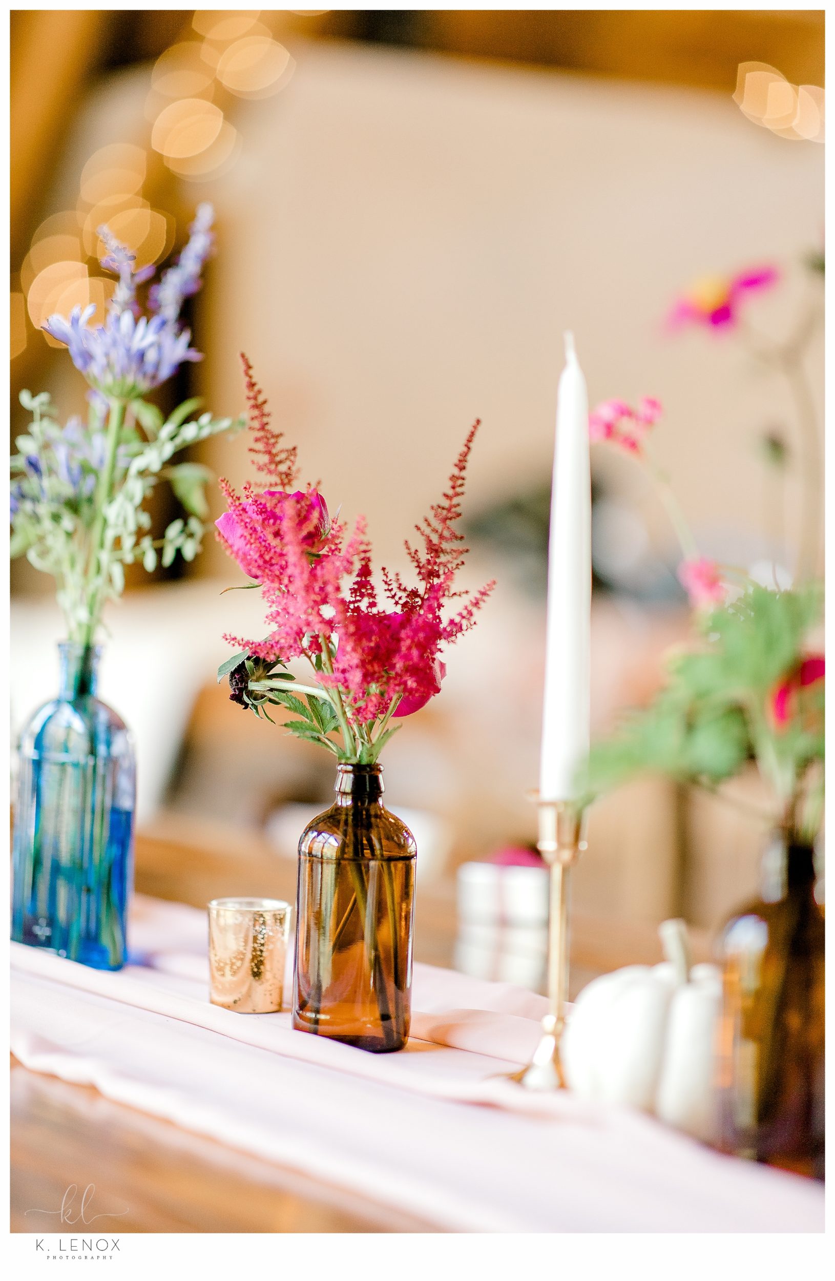 Reception Decor showing a table scape at Lake Falls Lodge.  Brown Bottle with pink flowers. 