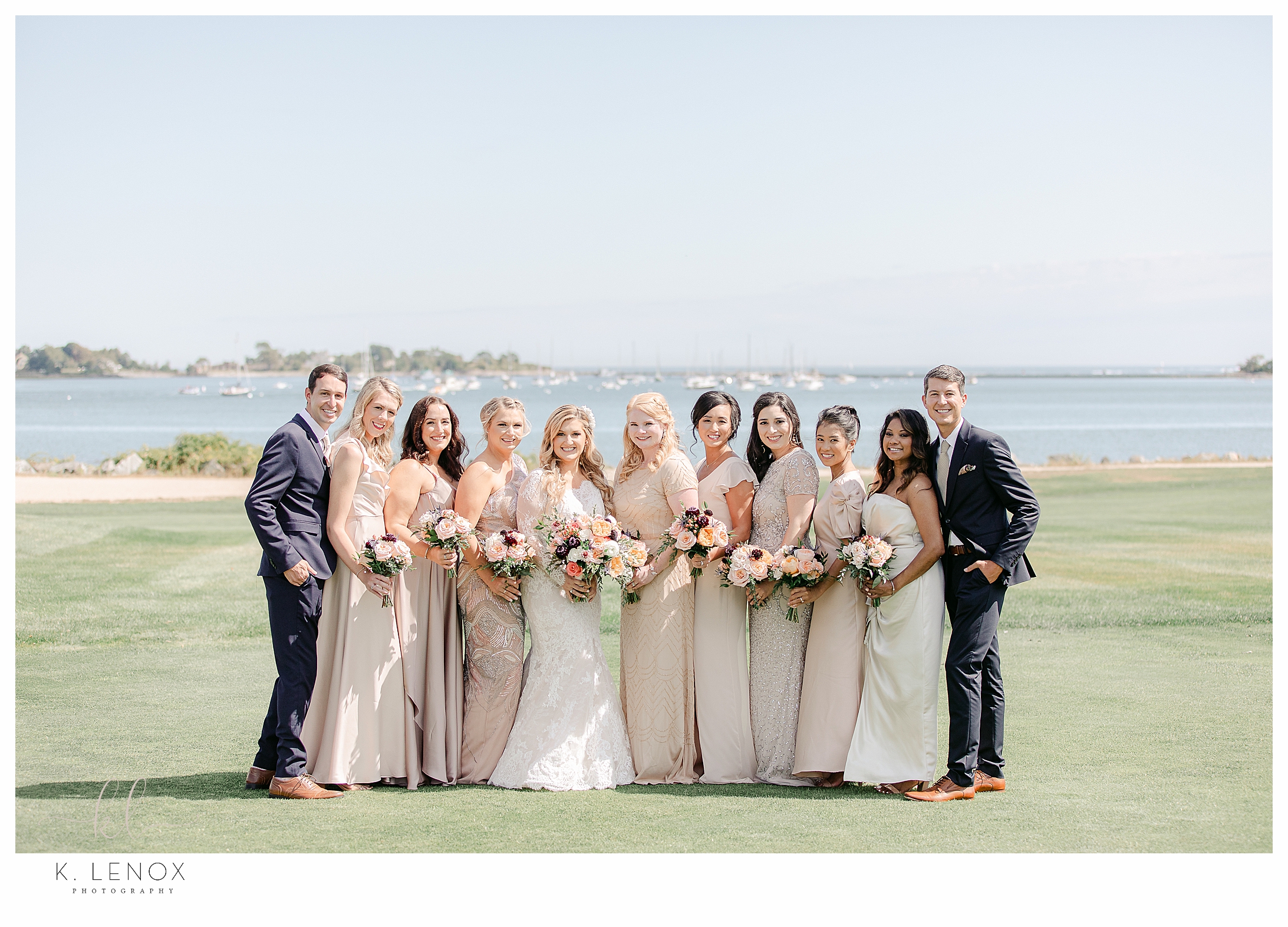 Wedding Party on the lawn of the Wentworth Country Club posing for a group photo.   Light and Airy, peachy neutral color dresses. 
