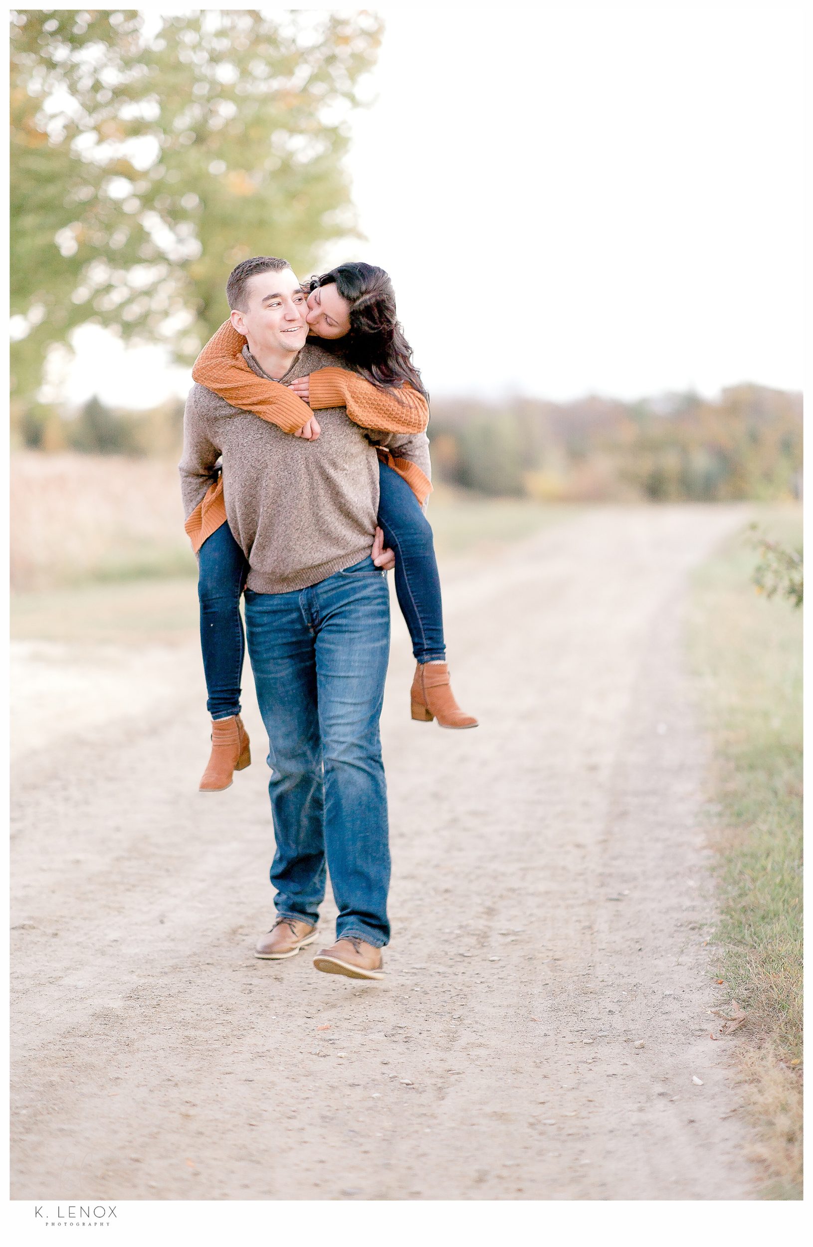 Fun and Carefree Engagement Session in NH- Man giving his fiance a piggy back ride. 