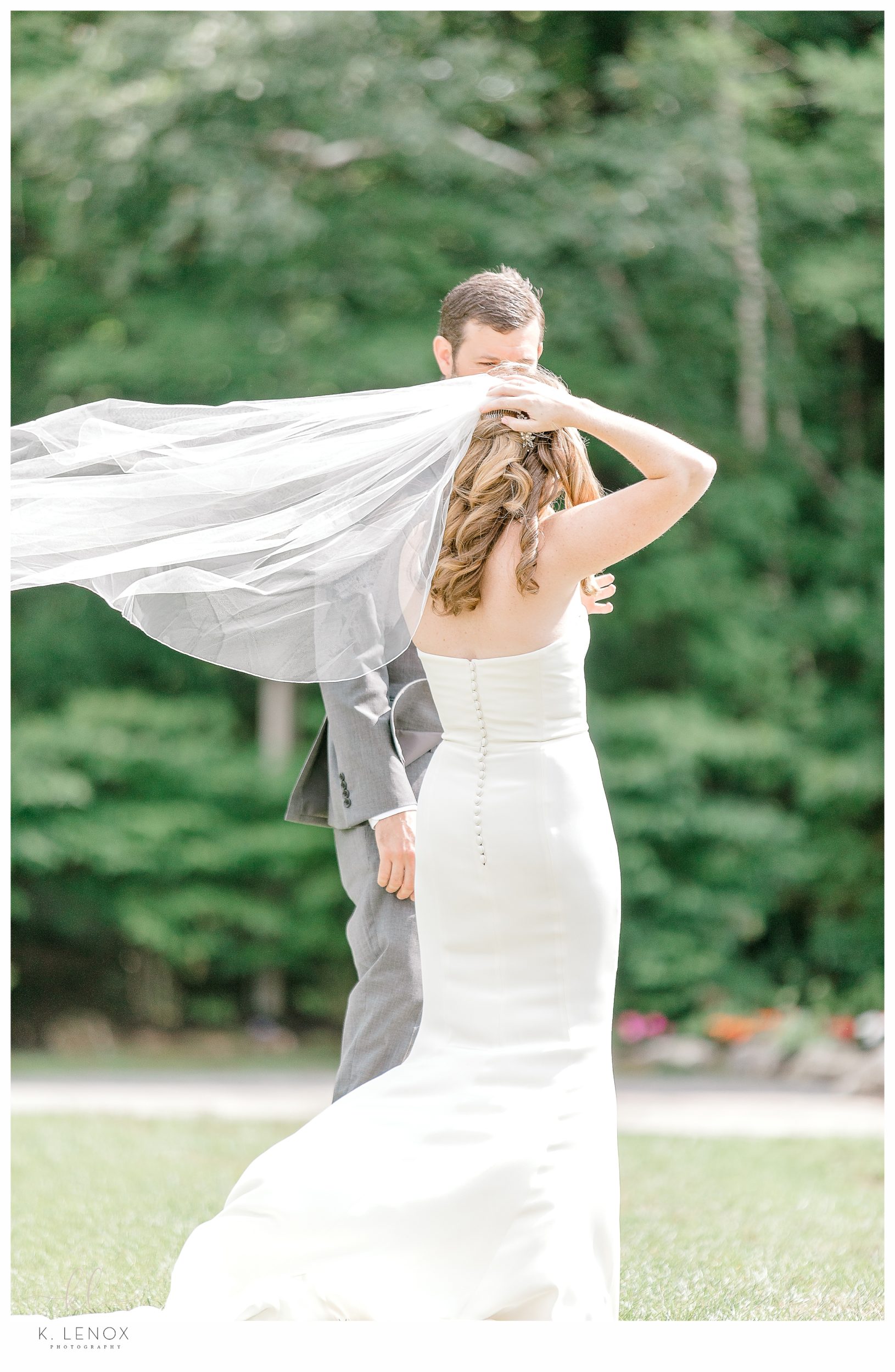 Bride Catches her veil as the wind blows at her wedding. 