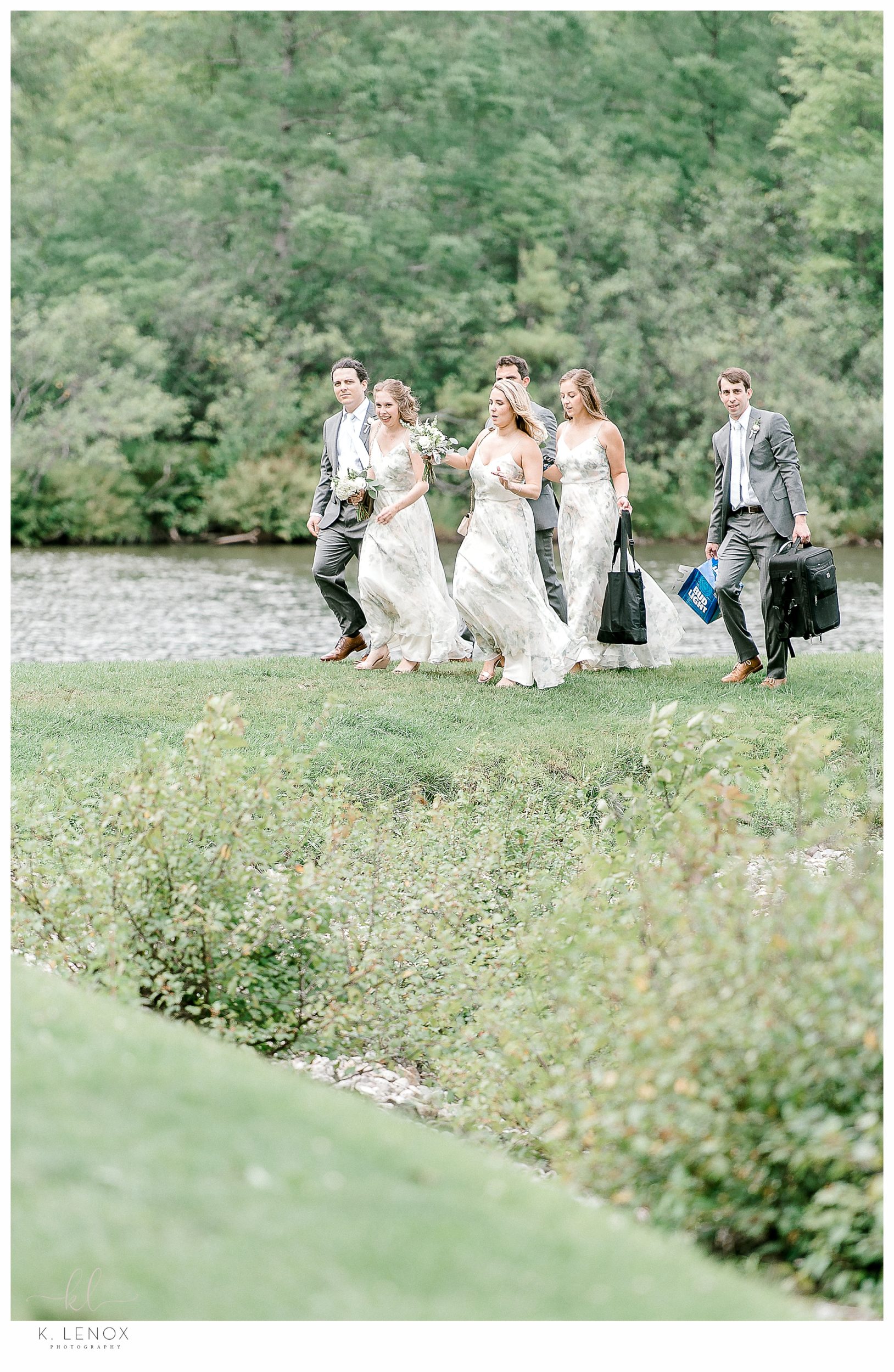 Candid photo of a wedding party walking next to a lake at the Equinox Resort. 