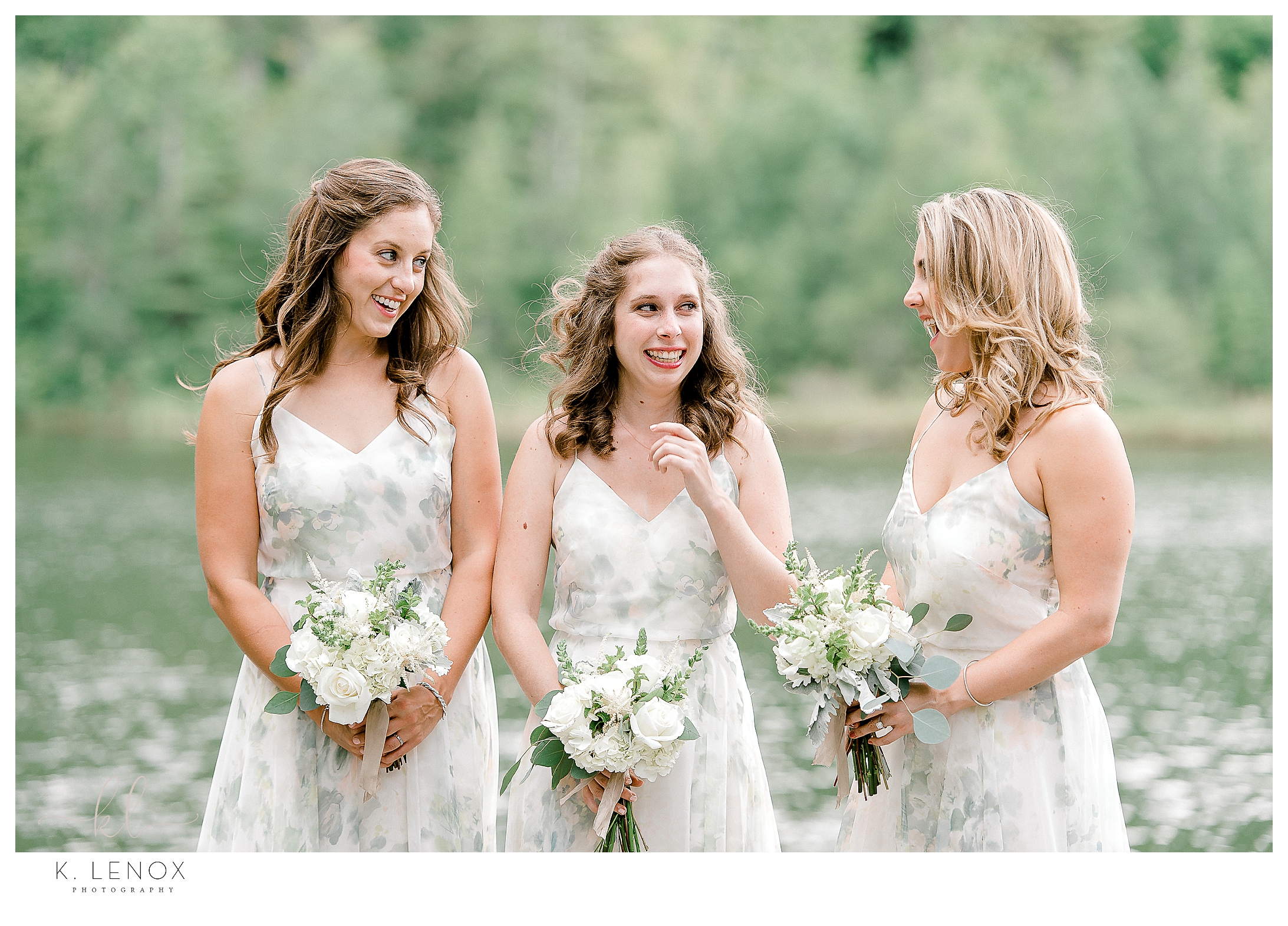Bridal party of three wearing soft pastel floral printed dresses and holding white floral bouquets. 
