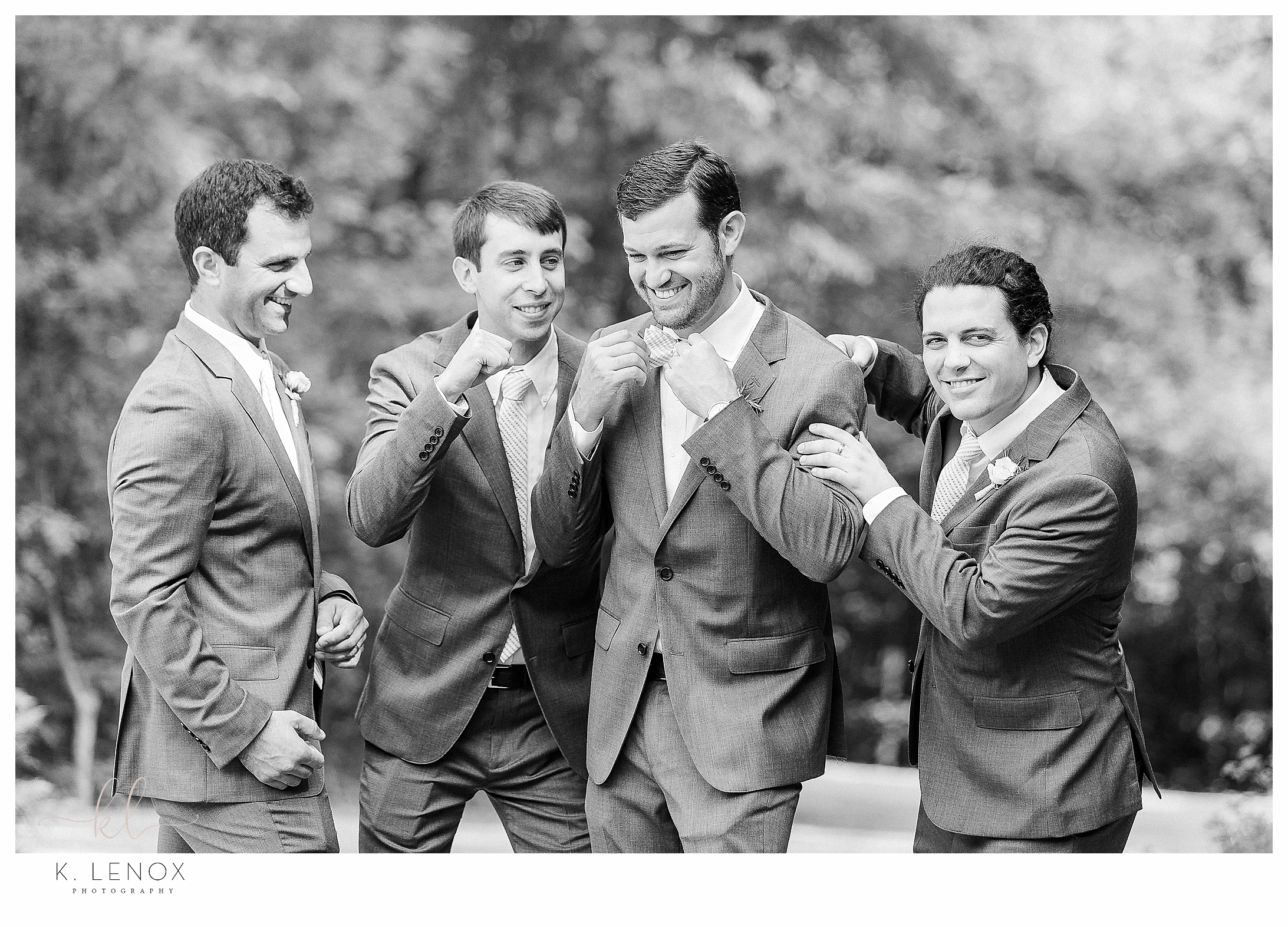 Black and White photo of a groom goofing around with his groomsmen. 